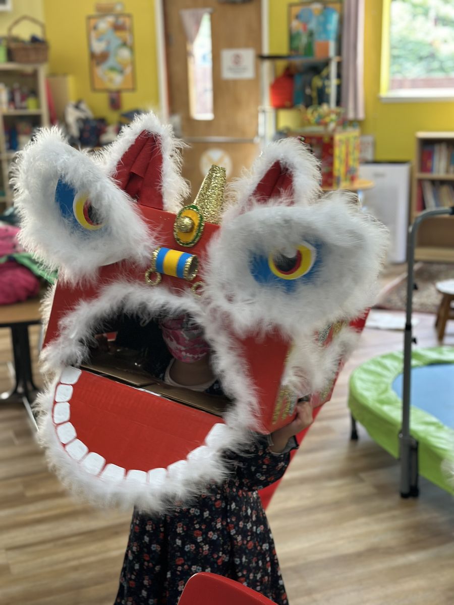 Child with a lion dance costume craft at Butterflies Academy