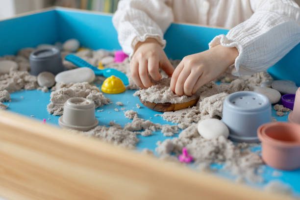 Sand sensory play with cups and tools