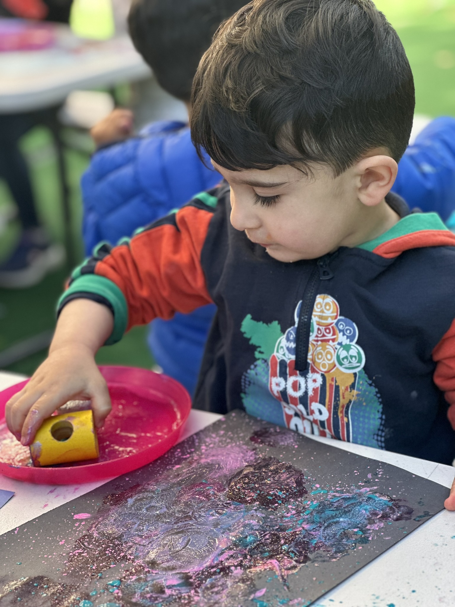 Child doing a splatter-art craft at Butterflies Academy